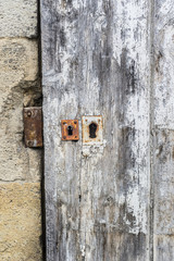 Weathered wooden door with white paint chipped and peeling.