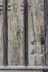 Weathered wooden door background with a metallic rusty rivets.