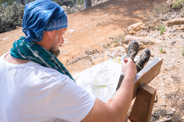 Bearded hiker on bench with map