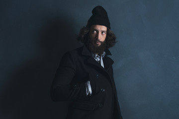 Retro 1970s beard man with long hair wearing black coat and wool