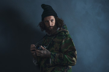 Vintage photographer with beard and long hair wearing camouflage