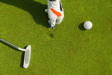 Male hand in glove marking ball position on the green. Focus on  pitchmark