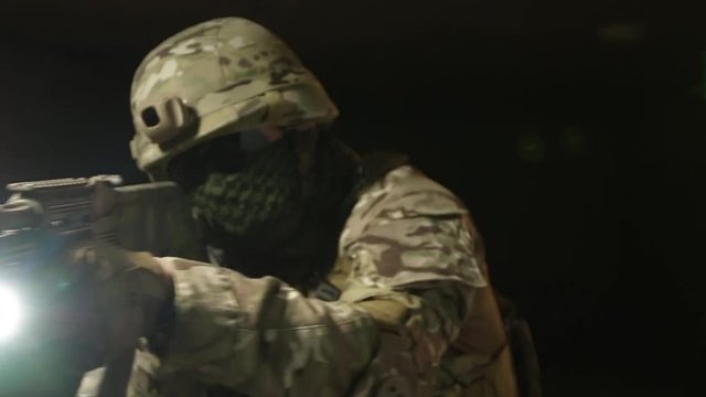 Soldier in a helmet with a flashlight to inspect the area