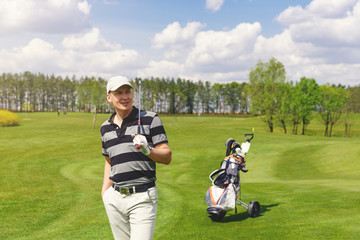 Portrait of male golfer standing at fairway on golf course