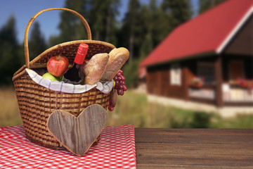 Picnic Table With Two Baskets And Fruits Near Country House