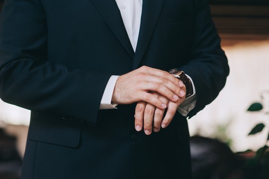 Man fastens his cuff links close-up. Businessman or fiance prepa