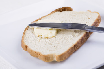 spreading butter in a slice of bread
