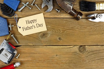 Happy Father's Day tag and corner border of tools on rustic wood background