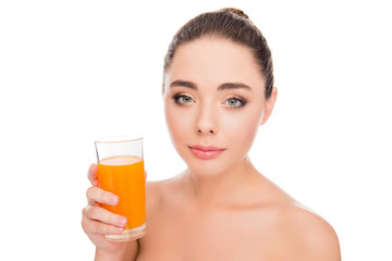 Pretty smiling young girl holding glass with orange juice