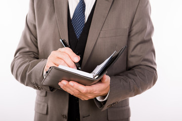 Close up photo of old businessman writing in his notepad