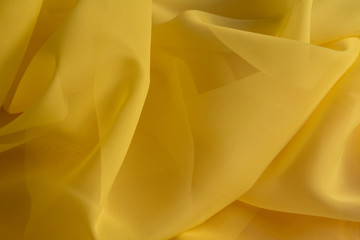 Shiny Yellow silky fabric folds background texture