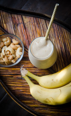 Banana cashew nut smoothie on palm leaf tray