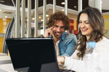 Couple using the laptop in the restaurant while take a lunch.