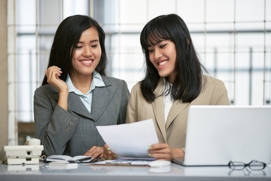 close up image of two businesswomen working and discussing in office
