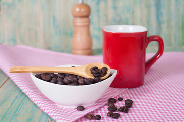 coffee beans in bolw with red cup