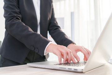 Closeup of business woman hand typing on laptop keyboard