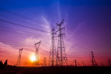 Fototapeta premium The silhouette of the evening electricity transmission pylon