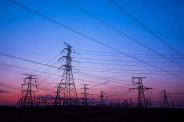 Fototapeta premium The silhouette of the evening electricity transmission pylon