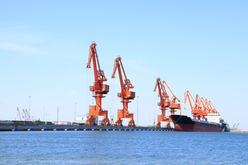 In freight terminal, gantry crane and cargo ships are in loading
