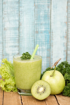 Light green healthy drink with ingredients on old wood