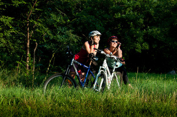 women cyclists sitting in the grass