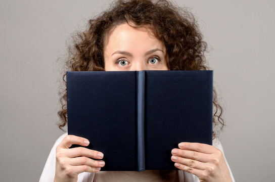 Woman hiding behind the book