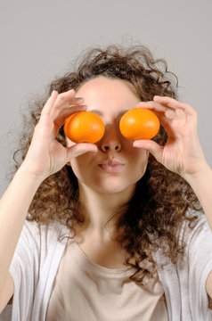 woman with tangerines on eyes