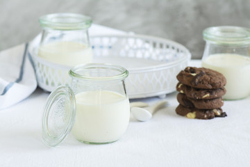 Homemade yogurt in a glass jars and chocolate cookies