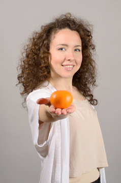 woman offers a tangerine