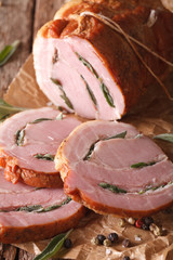 Spicy baked pork stuffed with sage close up on the table. Vertical
