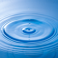 a water drop impact with water surface, causing rings on the sur