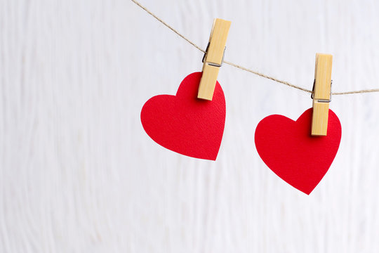 red hearts hanging on wooden background