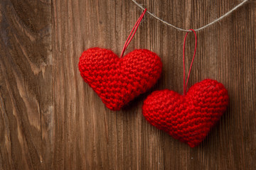 Two red heart hanging on wooden background