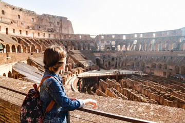 Young girl with backpack exploring inside the Colosseum (Coliseum)