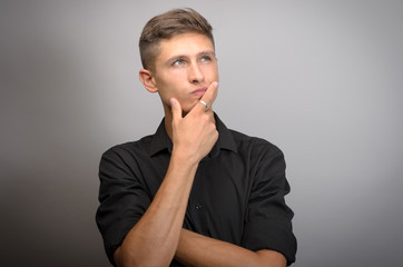 young handsome man doubting isolated over gray background