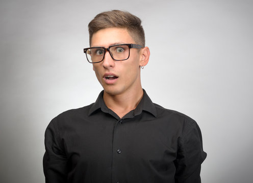 Portrait of a shocked young man in glasses