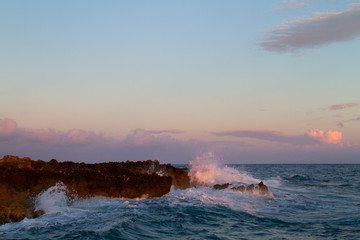 Waves breaking on the rocky shore of the Greek island Kefalonia, at sunset