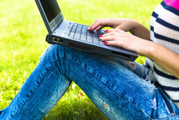 Young girl relax with laptop in summer park. 