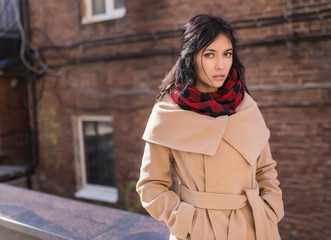 Fototapeta premium Young woman in a coat on the street.