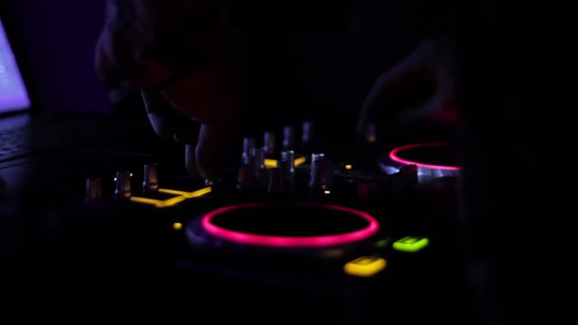 Hands of DJ which mixes music tracks PC mixer in nightclub 2