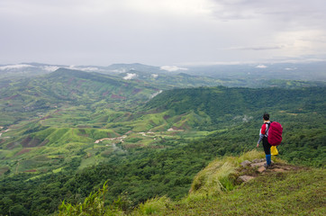 Obraz premium Man hiking enjoy the view at mountain peak cliff.