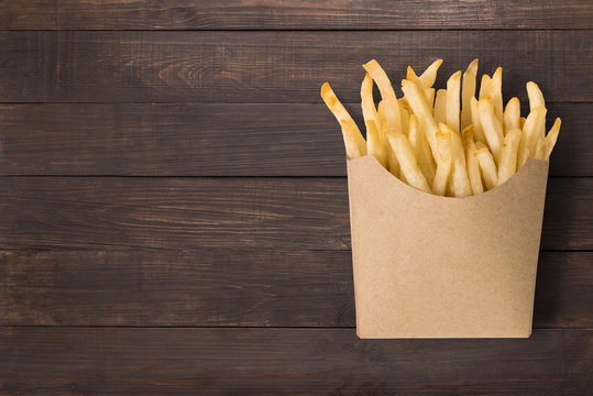 French fries on wooden background. Top view