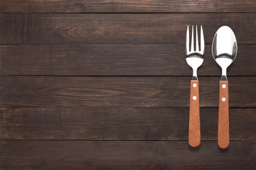 Eating concept. Spoon and fork on the wooden background
