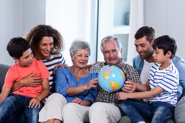 Happy family looking at a globe in living room