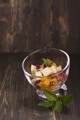 Fruit salad in glass bowls over dark background