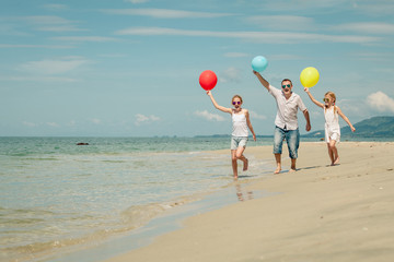 Father and children  playing on the beach at the day time.