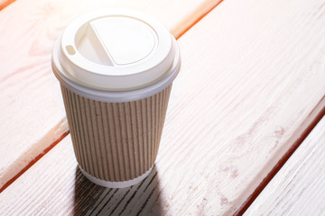 Cup with a lid. Paper cup with white lid. Latte cup on white table. Best coffee in town.