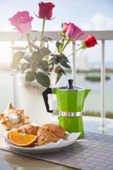 Breakfast with coffee on hotel's balcony, fresh croissants and s