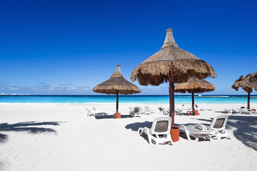 Beach chairs and sun umbrellas on a stunning tourist resort coas