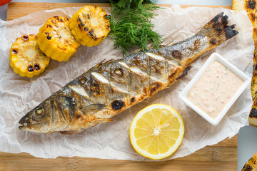 fish baked on the grill. with potatoes and lemon. 